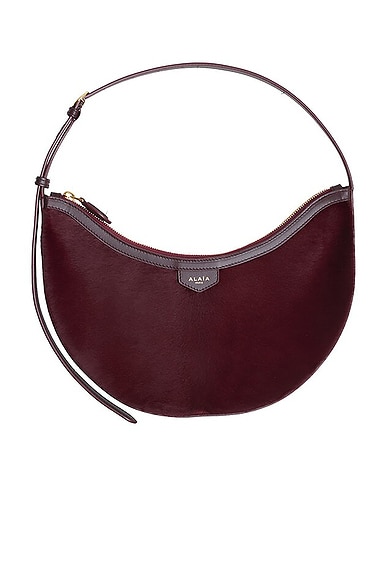 ALAÏA Demi Lune Haircalf Bag in Rouge Grenat